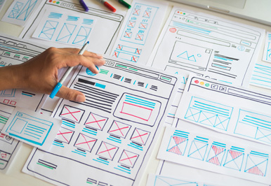 Hand sketching website wireframes on paper