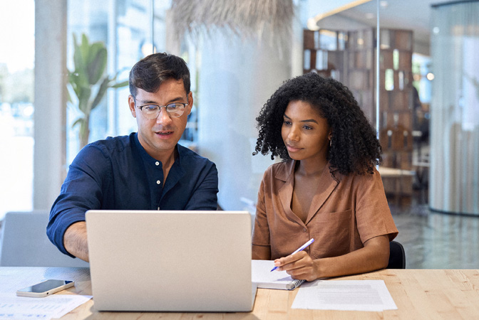 Two people collaborating on a laptop.